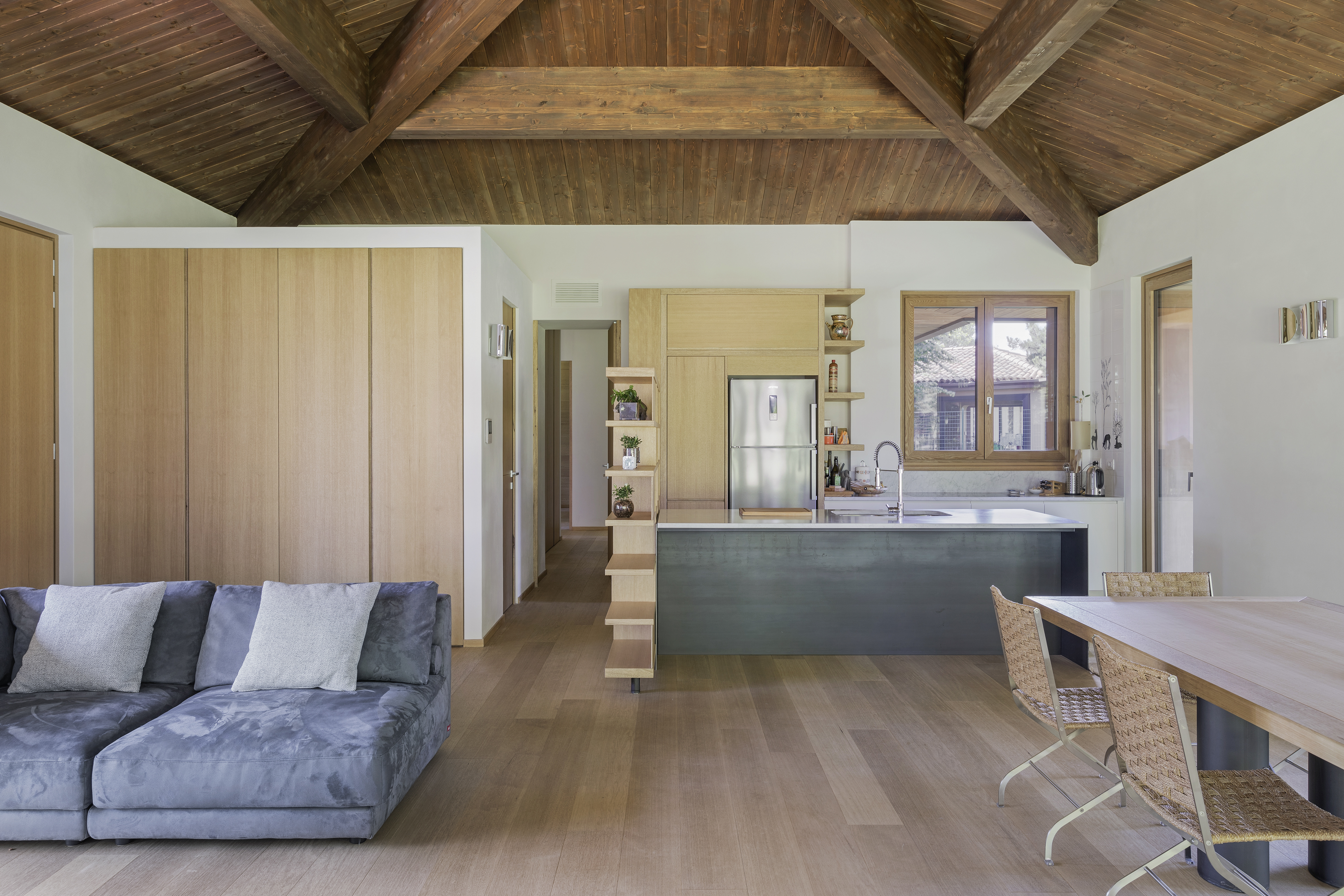 Interior: openspace with parquet floor and exposed wooden roof 